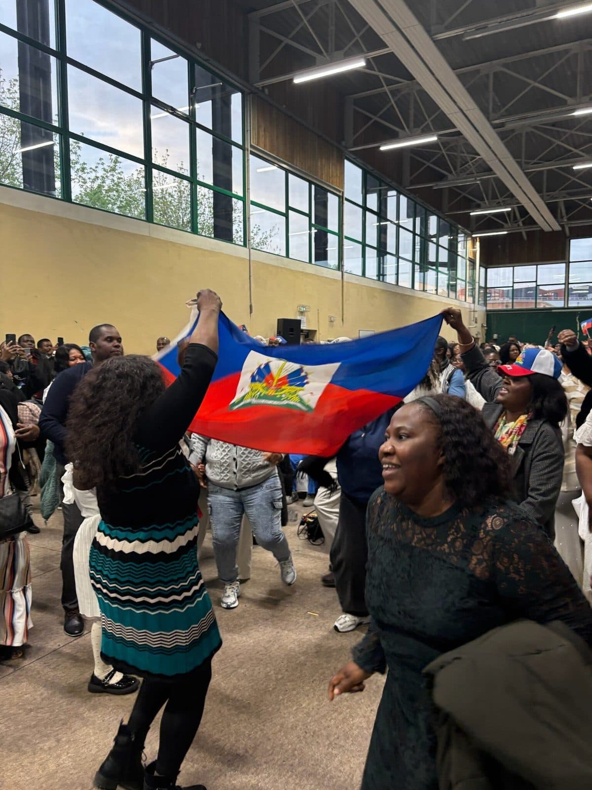 Drapeau haïtien brandi dans le public de la conférence APDH 2026
