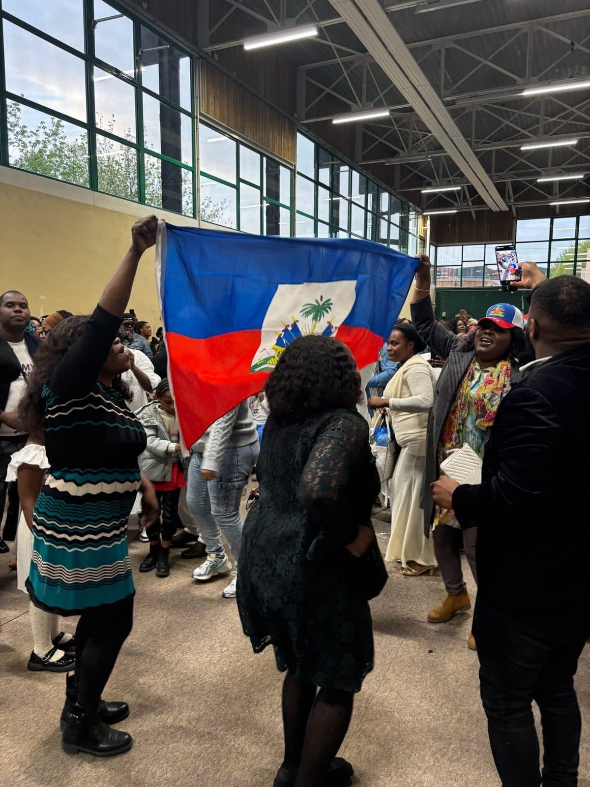 Drapeau haïtien brandi dans le public de la conférence APDH 2026