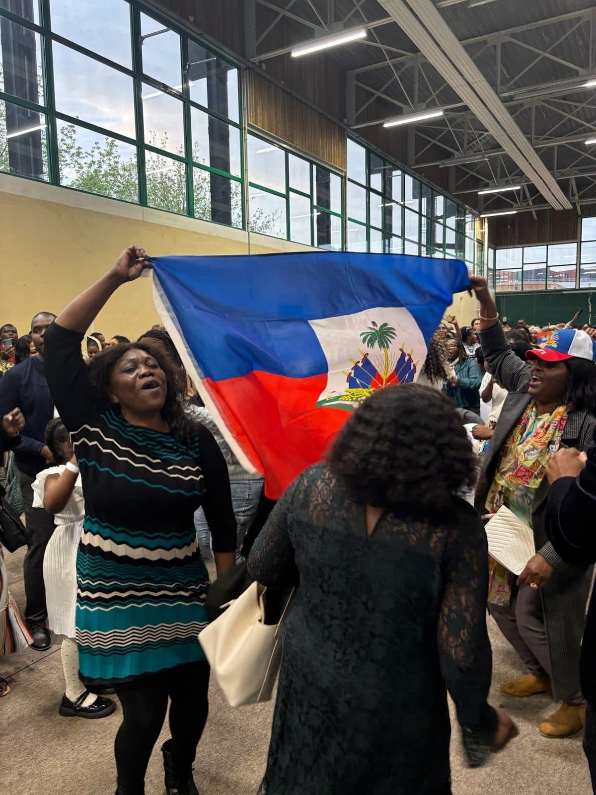 Drapeau haïtien brandi dans le public de la conférence APDH 2026