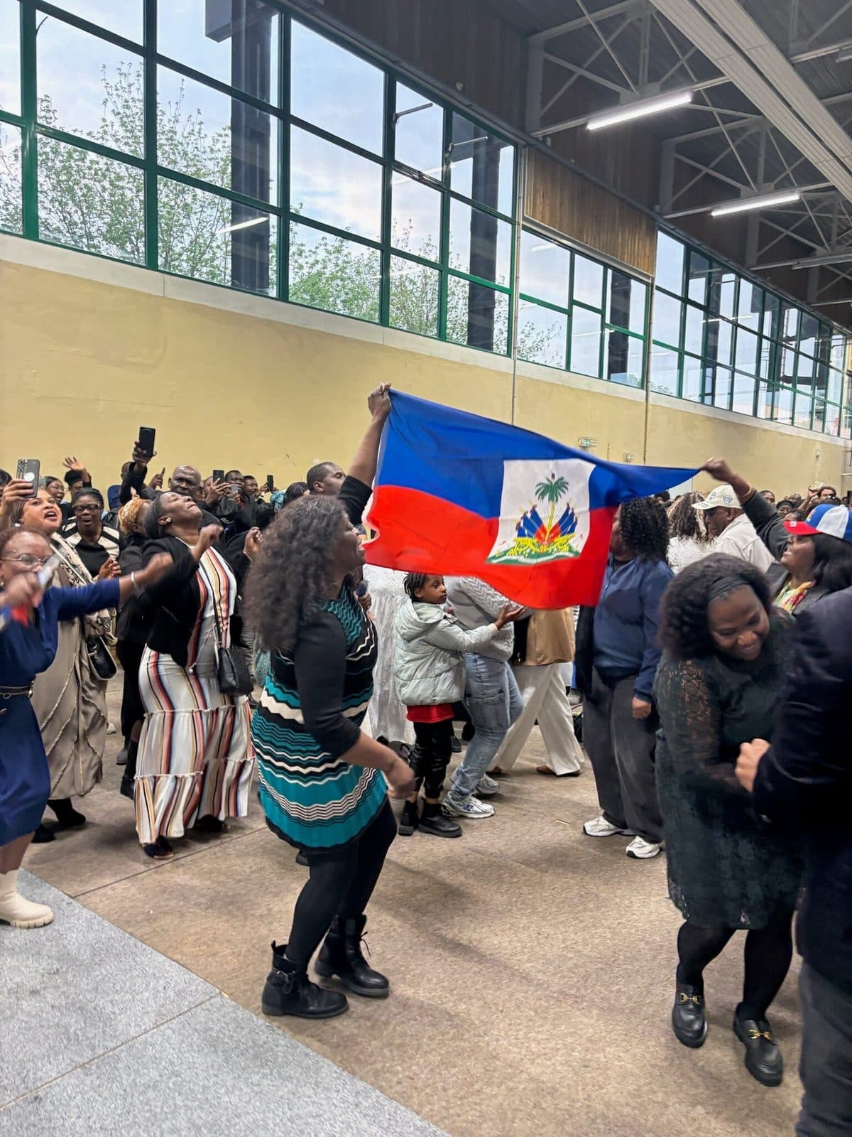 Drapeau haïtien brandi dans le public de la conférence APDH 2026