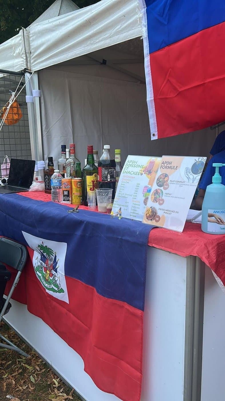 Stand de boissons et spécialités d'APDH, drapeau haïtien en arrière-plan